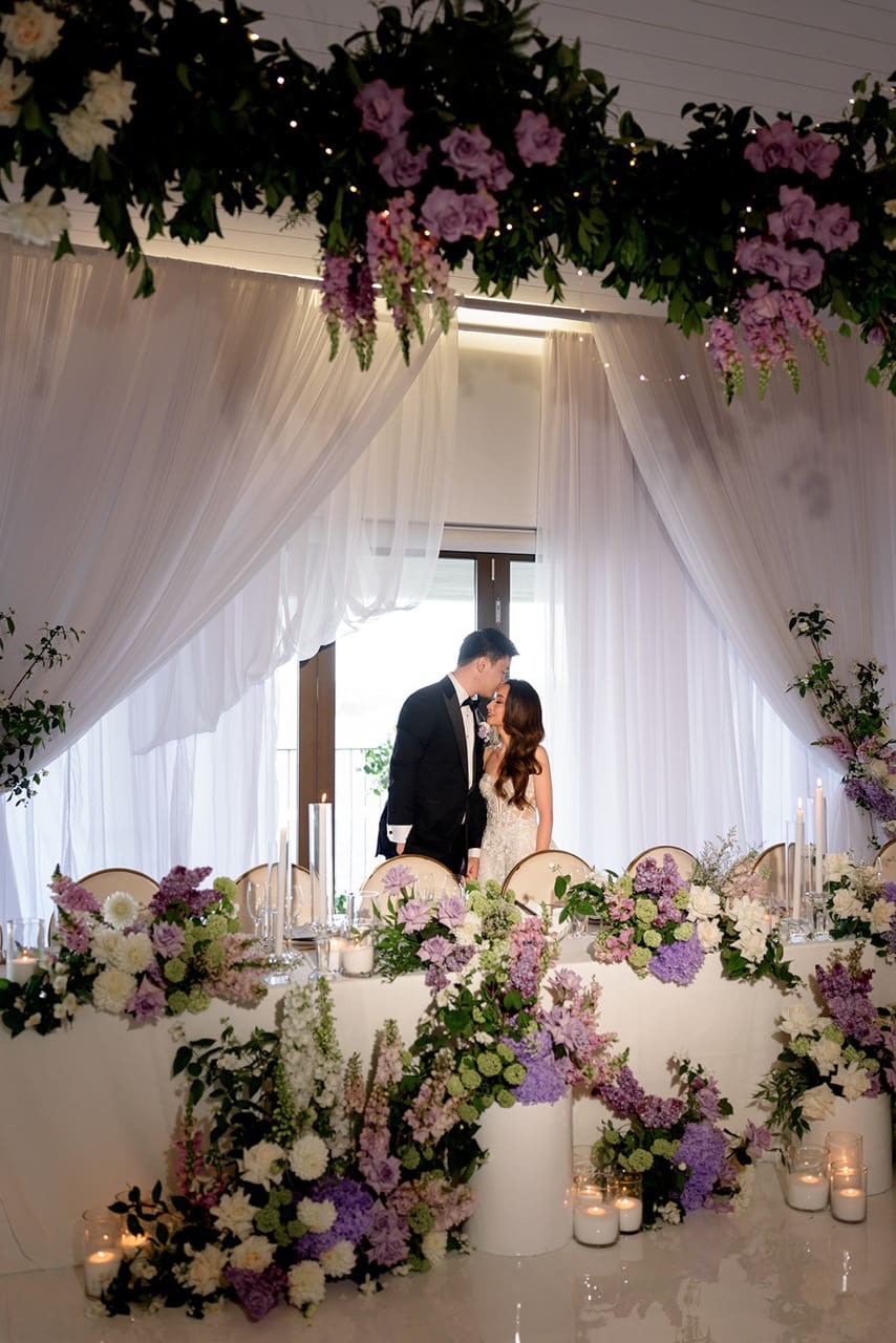 Bride and groom standing behind their styles bridal table at Sydney wedding venue Sergeants Mess